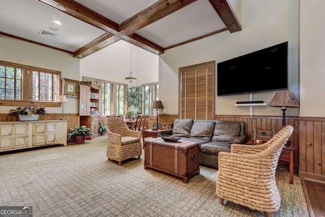 living room with wood walls, beam ceiling, light colored carpet, and ornamental molding