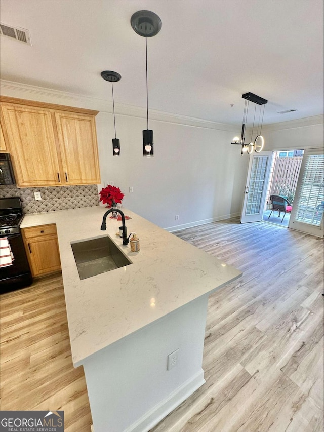 kitchen featuring sink, light hardwood / wood-style flooring, backsplash, kitchen peninsula, and black appliances