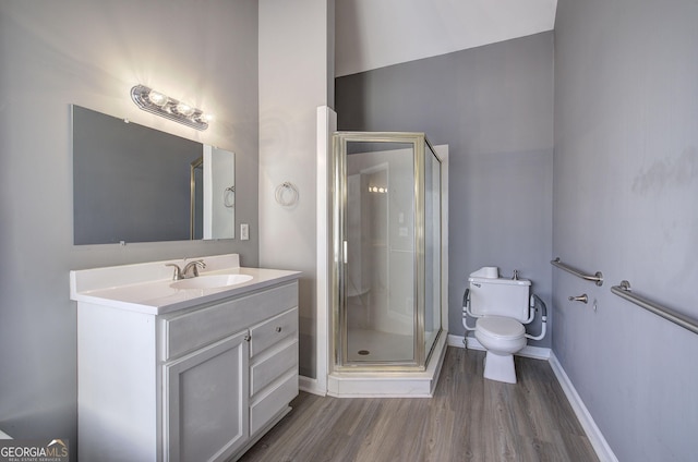 bathroom featuring a stall shower, baseboards, toilet, wood finished floors, and vanity