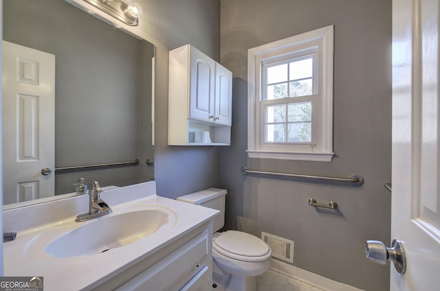 half bath with baseboards, visible vents, toilet, tile patterned floors, and vanity