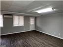 empty room with dark wood-type flooring, a wall mounted AC, and plenty of natural light