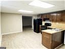 kitchen featuring dark brown cabinetry, kitchen peninsula, and refrigerator