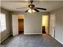 unfurnished bedroom with a walk in closet, a closet, and ceiling fan