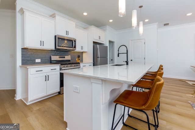 kitchen with white cabinetry, sink, an island with sink, and appliances with stainless steel finishes