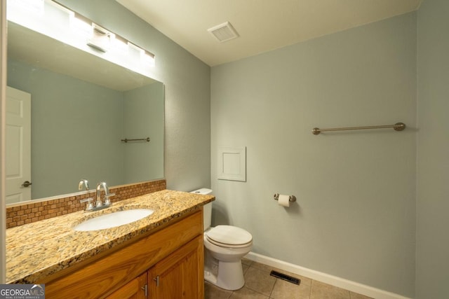 bathroom with tile patterned flooring, vanity, toilet, and backsplash