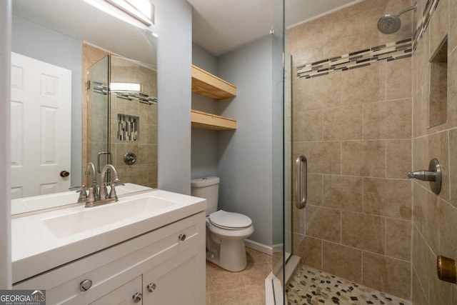 bathroom featuring toilet, vanity, tile patterned floors, and a shower with shower door