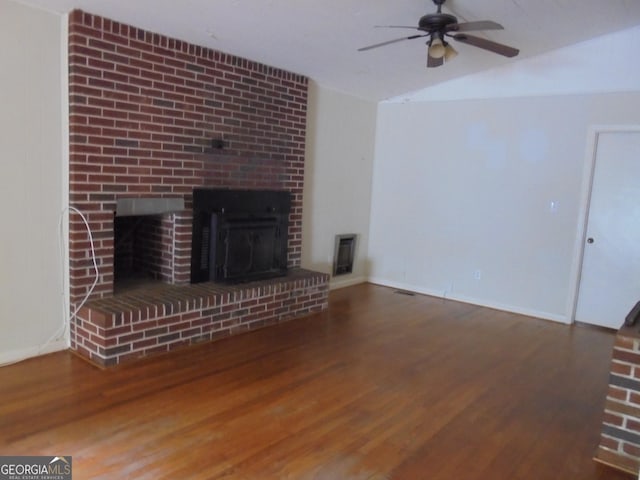 unfurnished living room with hardwood / wood-style flooring, ceiling fan, heating unit, and a brick fireplace