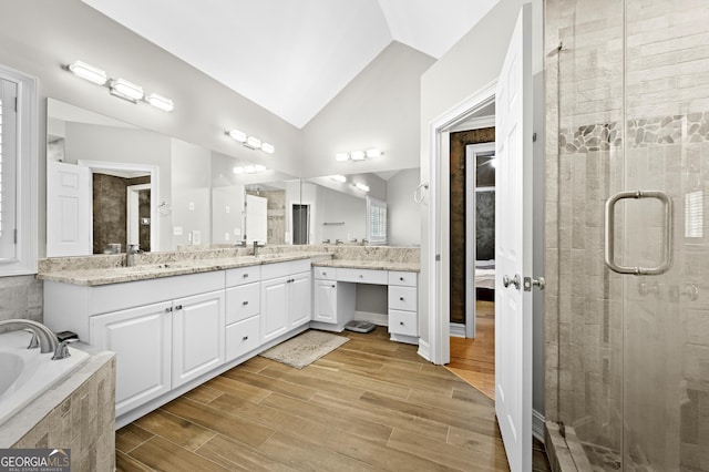 bathroom featuring vanity, hardwood / wood-style flooring, separate shower and tub, and lofted ceiling