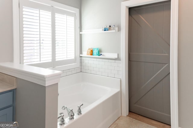 bathroom featuring tile patterned floors, plenty of natural light, vanity, and a bath