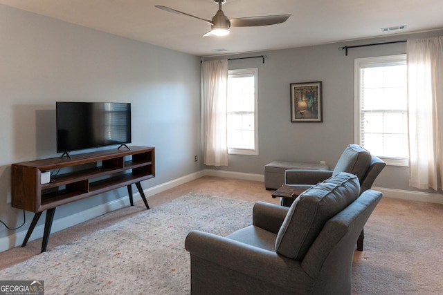 carpeted living room with ceiling fan