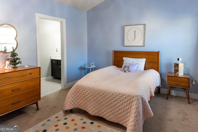 bedroom featuring connected bathroom and light colored carpet