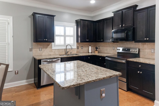 kitchen featuring a center island, stainless steel appliances, light wood-type flooring, and sink