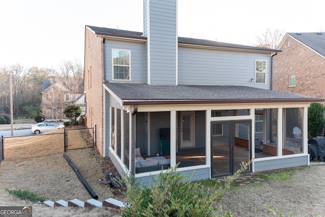 rear view of house featuring a sunroom