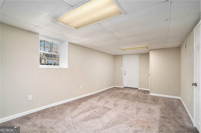 basement with carpet and a paneled ceiling