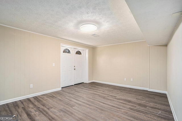 entryway with wood-type flooring, a textured ceiling, and ornamental molding