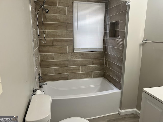 full bathroom with tiled shower / bath combo, toilet, wood-type flooring, and vanity