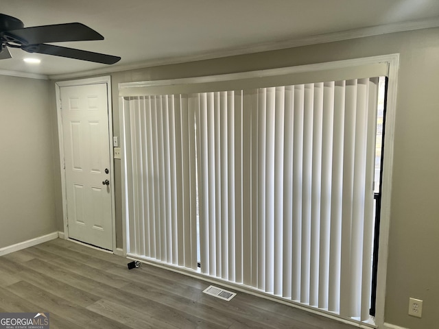 interior space featuring wood-type flooring, radiator, crown molding, and ceiling fan