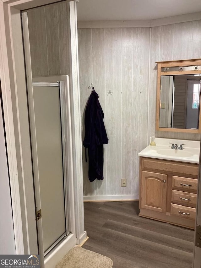 bathroom featuring vanity, wood-type flooring, and an enclosed shower