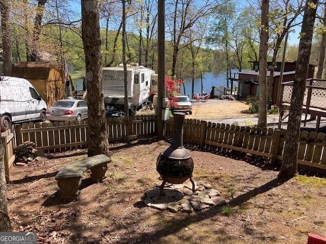 view of yard featuring a water view and a fire pit