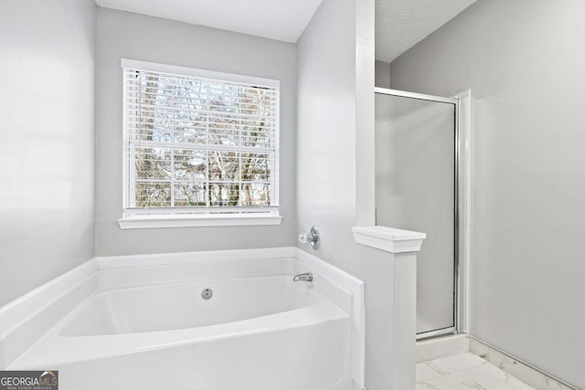 bathroom with plus walk in shower and a textured ceiling