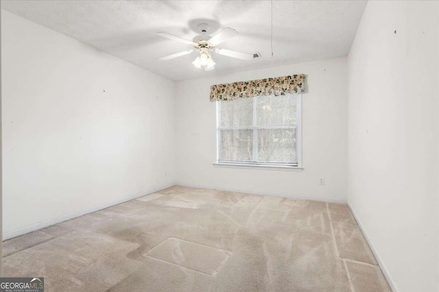 carpeted empty room with ceiling fan and a textured ceiling