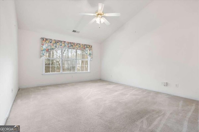 empty room featuring lofted ceiling, ceiling fan, and carpet flooring