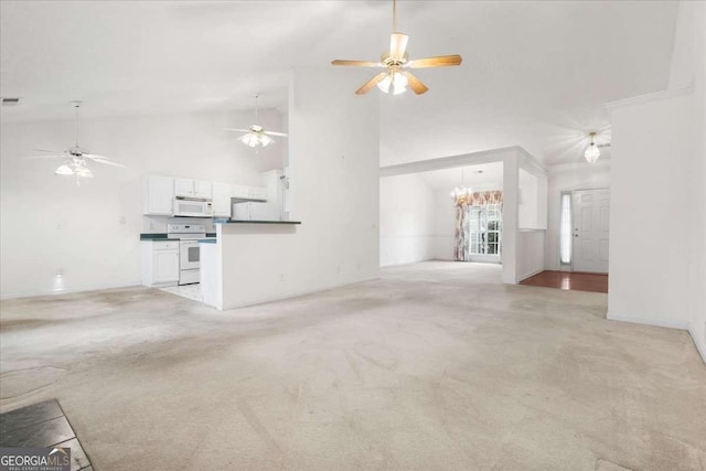 unfurnished living room featuring high vaulted ceiling, light colored carpet, and a notable chandelier