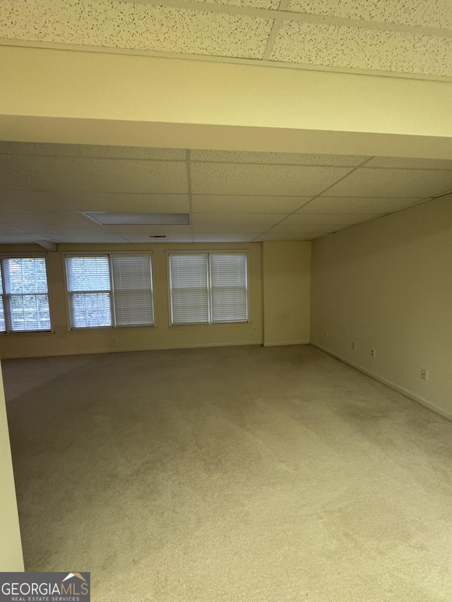 empty room with carpet flooring and a drop ceiling