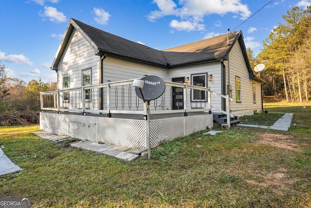 view of property exterior with a lawn and a deck