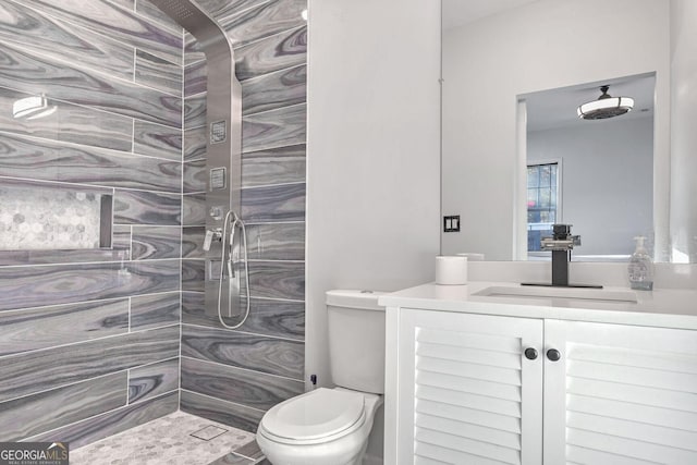 bathroom featuring vanity, toilet, and a tile shower