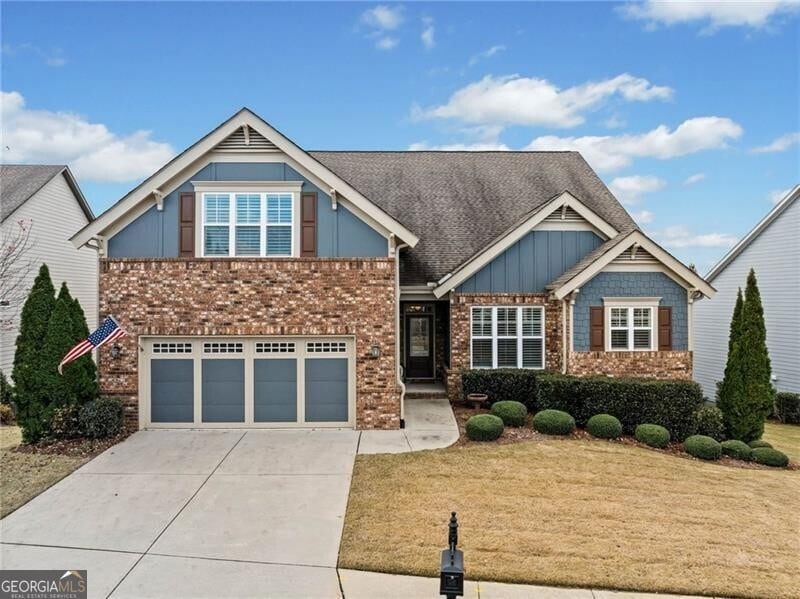 craftsman house with a front lawn and a garage