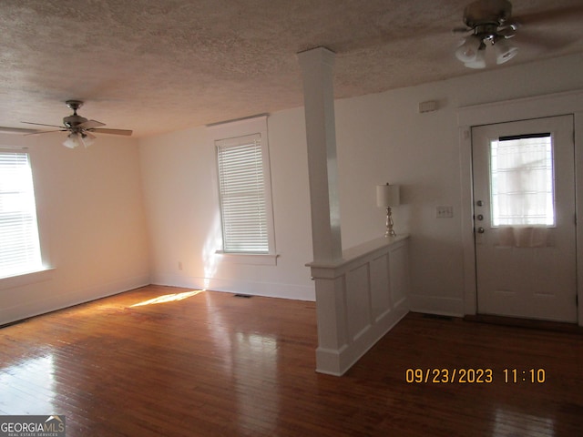 foyer entrance with ornate columns, ceiling fan, a textured ceiling, and hardwood / wood-style flooring