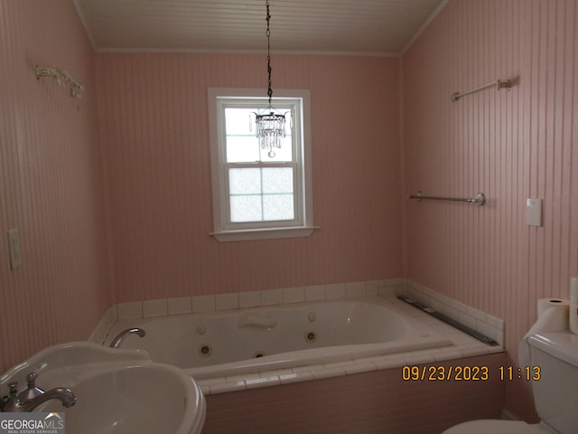 bathroom with toilet, tiled tub, crown molding, and sink