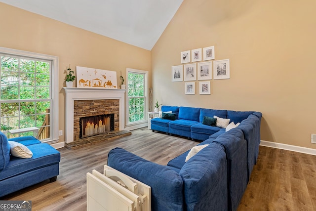 living room featuring hardwood / wood-style flooring, a fireplace, and high vaulted ceiling