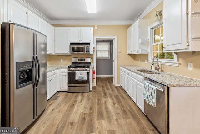 kitchen featuring sink, crown molding, stainless steel appliances, and white cabinets