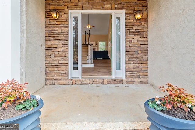 view of exterior entry with stucco siding and stone siding