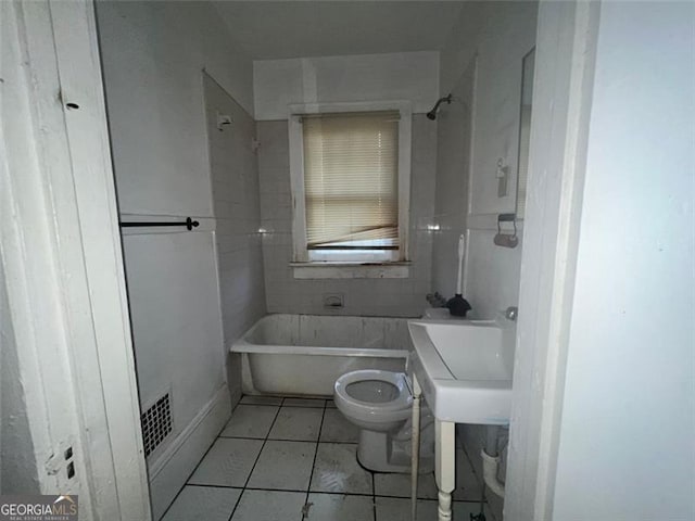 bathroom featuring toilet, tile patterned floors, and a bathtub