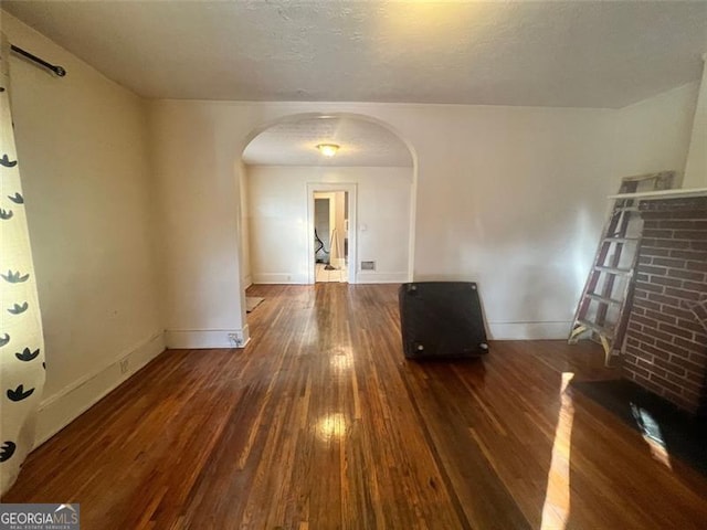 spare room featuring dark hardwood / wood-style floors and a textured ceiling