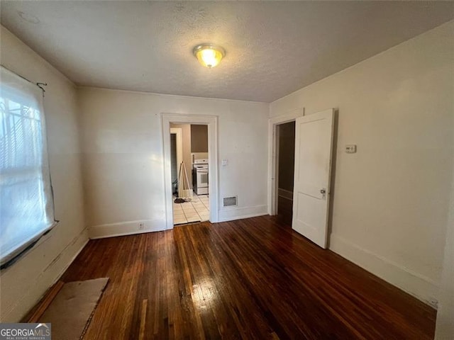 empty room featuring a healthy amount of sunlight, a textured ceiling, and light hardwood / wood-style flooring