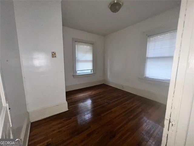 spare room with dark wood-type flooring