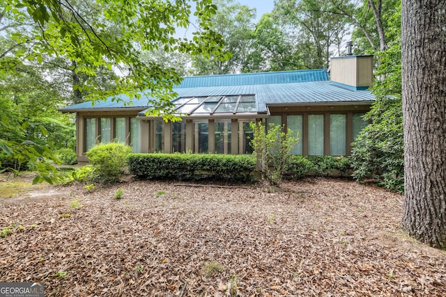 back of property with a sunroom