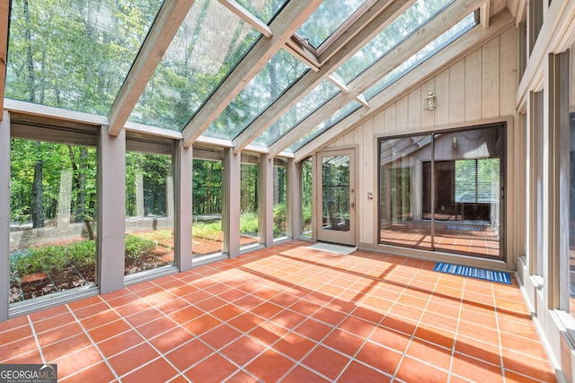 unfurnished sunroom featuring lofted ceiling with skylight