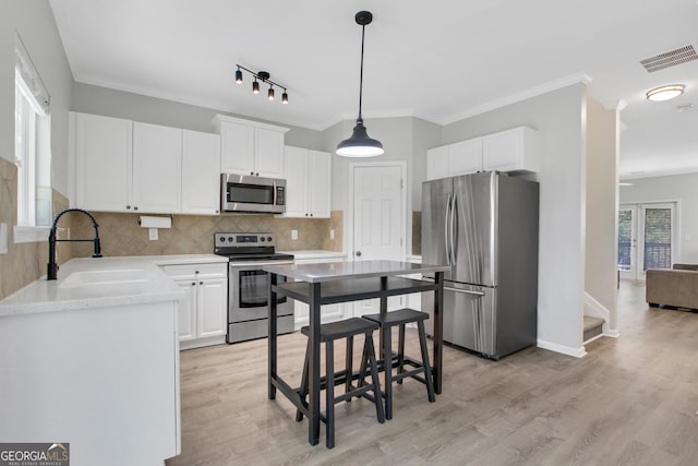 kitchen with a sink, visible vents, stainless steel appliances, and light wood-type flooring
