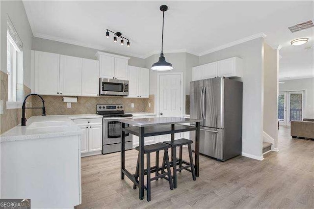 kitchen featuring white cabinets, light wood-type flooring, stainless steel appliances, and sink