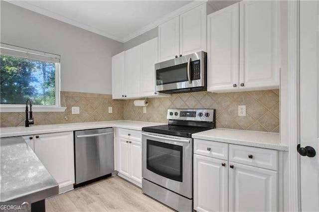 kitchen with white cabinetry, crown molding, and appliances with stainless steel finishes