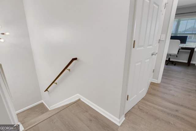 stairs with wood finished floors and baseboards