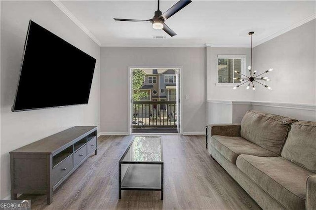 living room with light hardwood / wood-style flooring, a healthy amount of sunlight, and ornamental molding