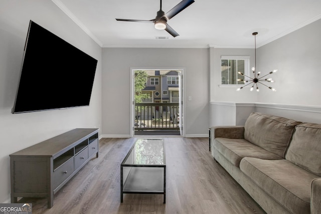 living room featuring visible vents, baseboards, ceiling fan with notable chandelier, wood finished floors, and crown molding