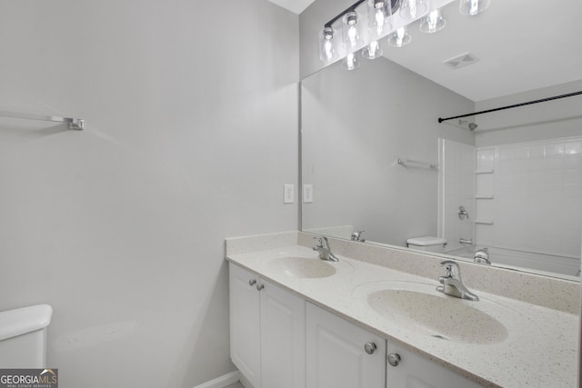 bathroom with double vanity, visible vents, toilet, and a sink