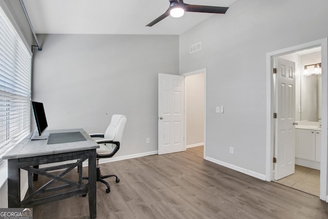 office space with wood finished floors, visible vents, ceiling fan, and a healthy amount of sunlight